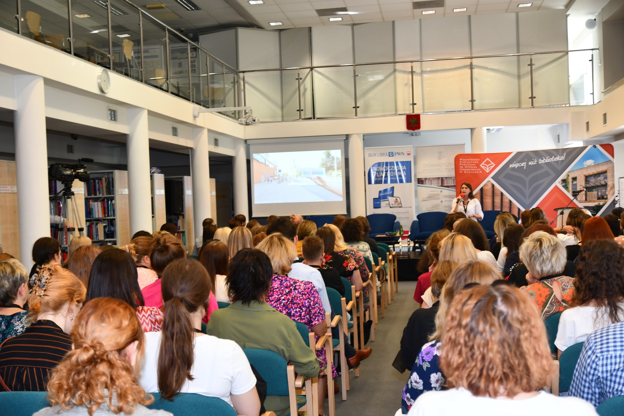 widownia forum, dwa szeregi krzeseł na sali z antresolą