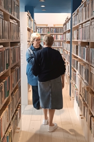 Dwie bibliotekarki stoją między regałami