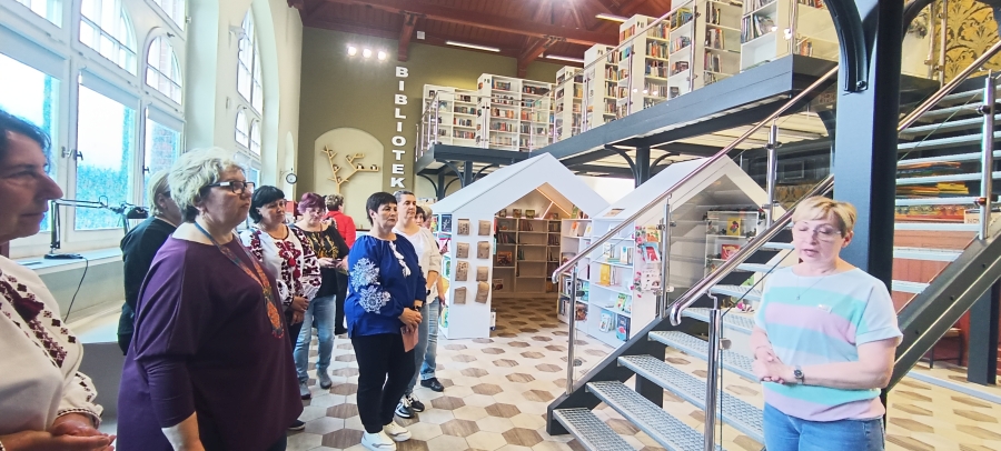 Grupa bibliotekarzy w nowoczesnym holu biblioteki