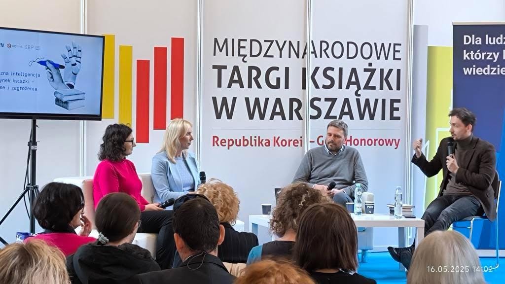 Czterech panelistów dyskutują na scenie, w tle logo targów książki w Warszawie.